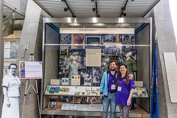 A mother and son stand together at a Vietnam War veterans exhibit.