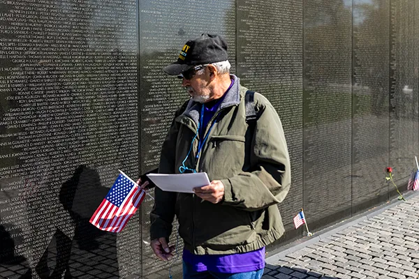 A man reads names on the Vietnam Veterans Memorial Wall.