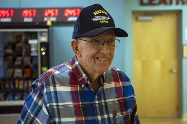 An older man wearing a WWII veteran ballcap