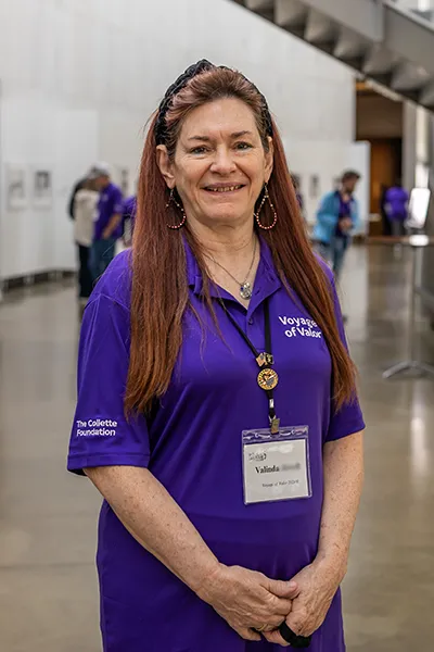 A woman with a Wish of a Lifetime name tag stands indoors.