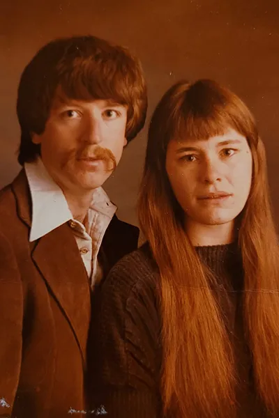 A man and woman pose together in a 1970s photograph.