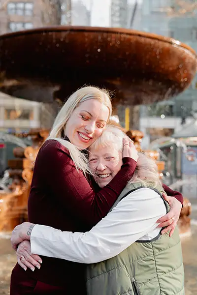 A younger woman hugs an older woman.