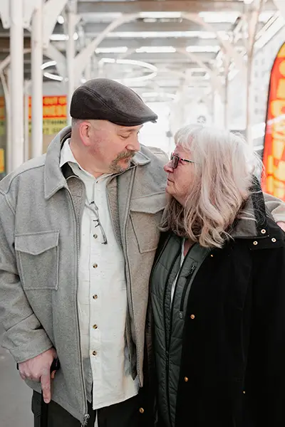 An adult mother and son look at one another.