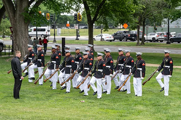 A group of military soldiers march in formation