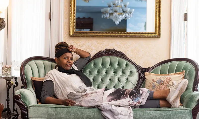 A woman relaxes on an antique sofa