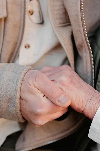 Two adults clasp hands.