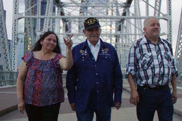 Closeup photo of three people standing on a bridge