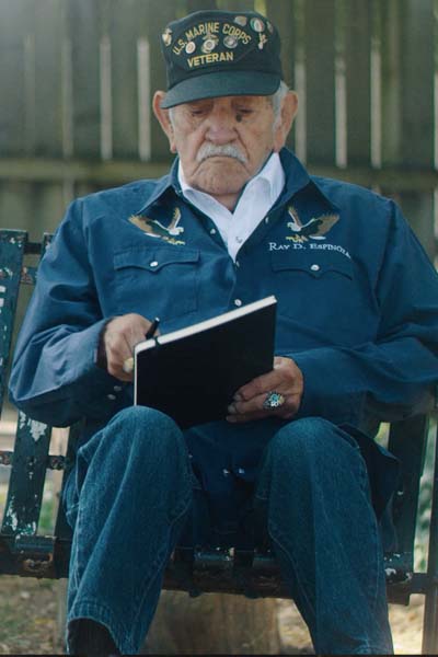 An older man in uniform looks at a notebook