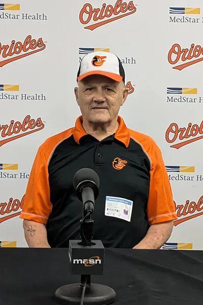 A man sits in behind a microphone at a Baltimore Orioles press conference.
