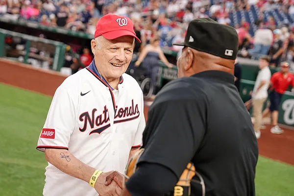 A man shakes hands with a baseball official.