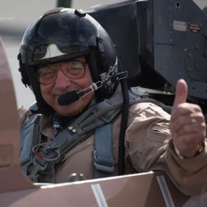 Pilot sitting in airplane cockpit with thumb up